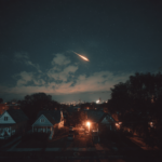 Dramatic night sky over Cleveland, Ohio, with a bright meteor streaking across the sky